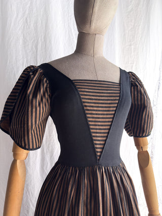 Vintage 1970s French day dress in a striped cotton fabric with dramatic puff sleeves and a tailored waist, displayed on a mannequin.