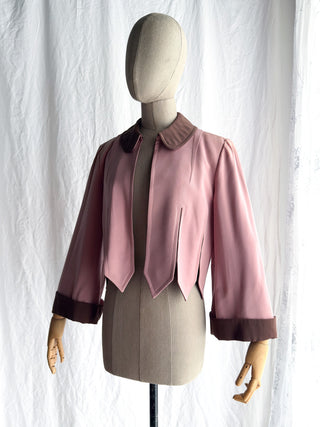 A vintage 1940s pink jacket with dark brown trim being worn open in the front