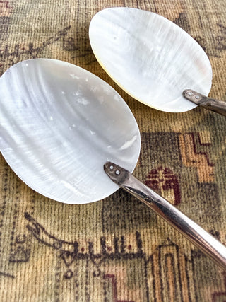 Two vintage mother-of-pearl spoons with silver-toned metal handles